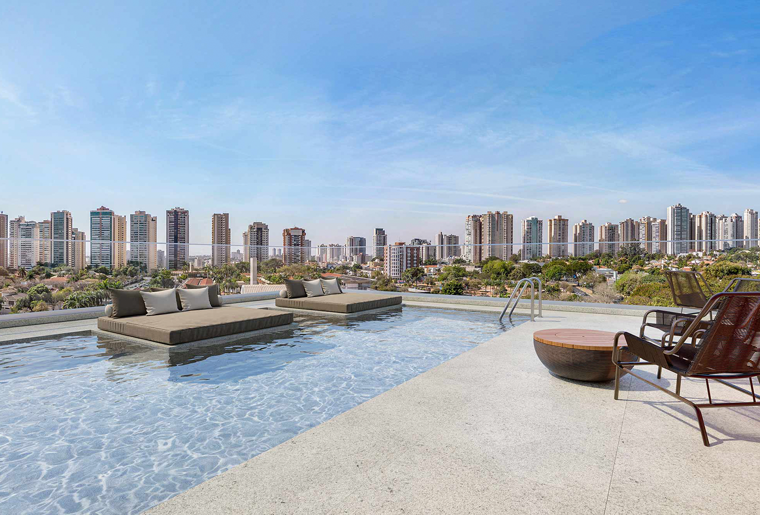 Piscina com espreguiçadeiras e sofás sobre a água, em rooftop com vista panorâmica de prédios e céu azul
