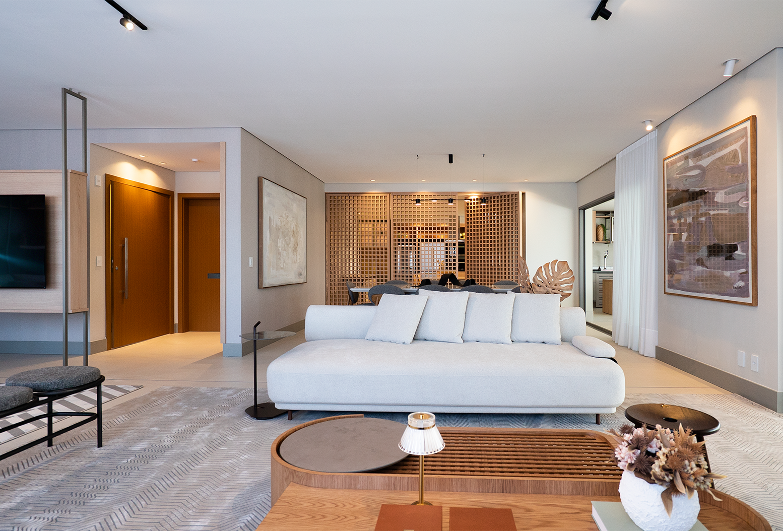 Sala com quadro abstrato e decoração em tons neutros e madeira natural