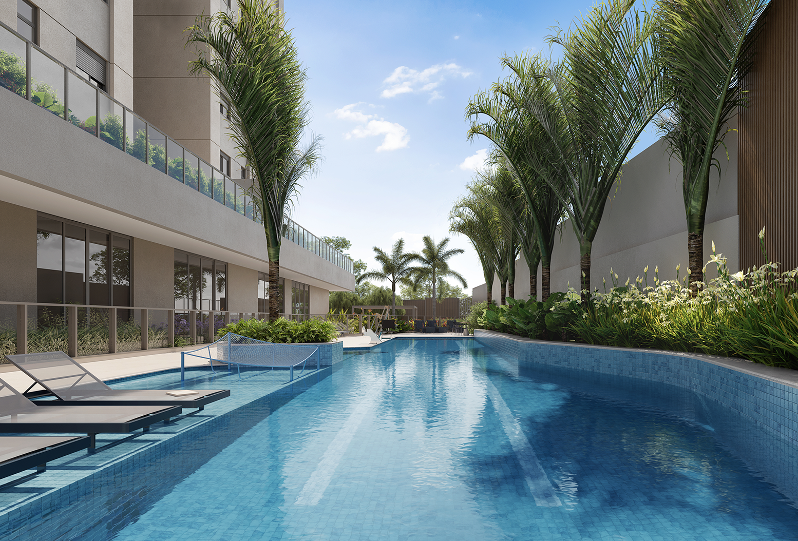 Grande piscina extensa com espreguiçadeiras nas laterais, bem ao lado do edifício e vegetação ao redor.