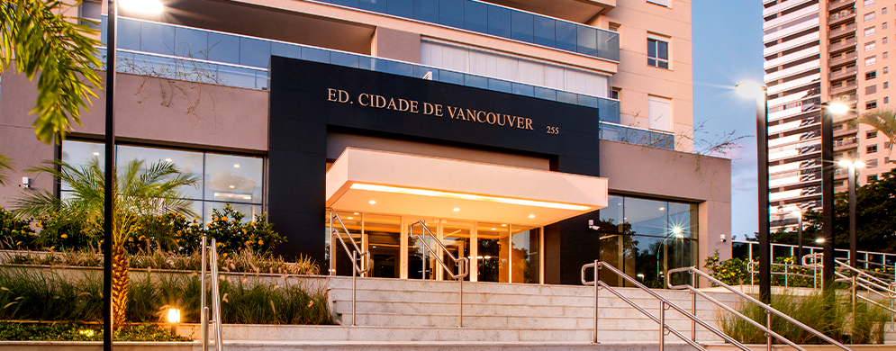 Entrada social do edifício Cidade de Vancouver com escadaria, jardim, portaria e varandas ao fundo.