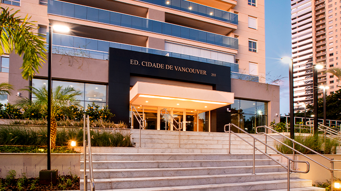 Entrada social do edifício Cidade de Vancouver com escadaria, jardim, portaria e varandas ao fundo.