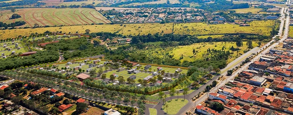  Imagem aérea que mostra lotes bem definidos em meio à natureza, com algumas casas já construídas e grande parque ao centro.