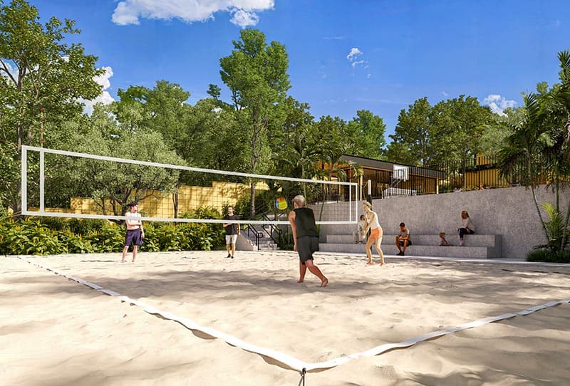 Imagem de quadra de areia com pessoas jogando vôlei, ao fundo, quadra poliesportiva e área verde ao redor.