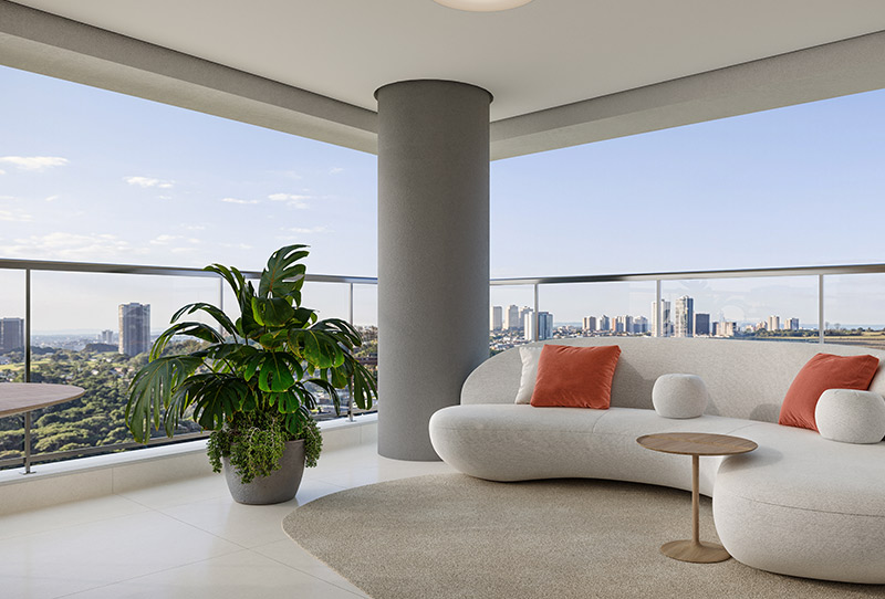 Varanda ampla com sofá curvo branco, almofadas terracota, mesa de apoio, planta tropical e vista panorâmica da cidade.